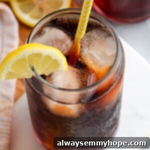 Top down view of Southern sweet tea in glass with ice and straw, with lemon wedge on rim