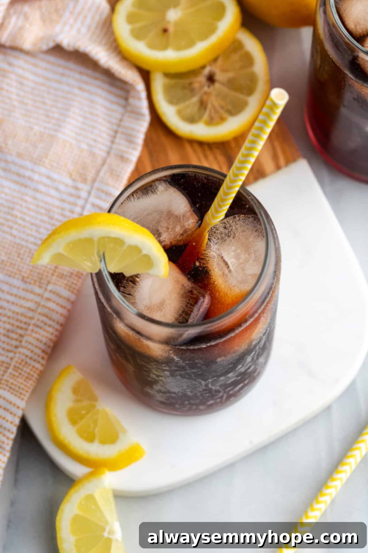 Top down view of a single glass of Southern sweet tea, brimming with ice and garnished with a bright lemon slice, emphasizing its refreshing appeal.