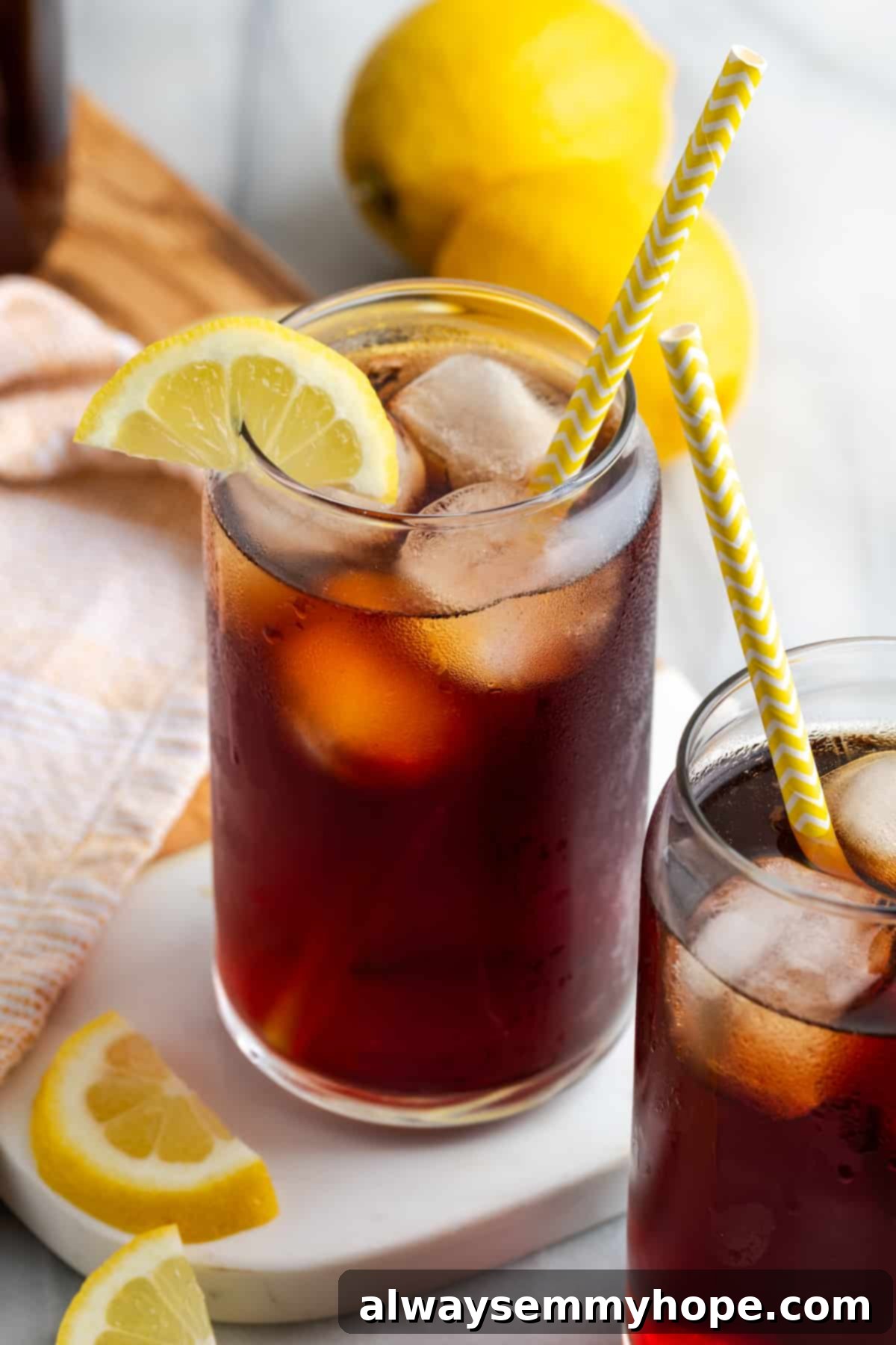 A single glass of Southern sweet tea, filled with ice and a lemon wedge, positioned on a wooden table, inviting a refreshing sip.