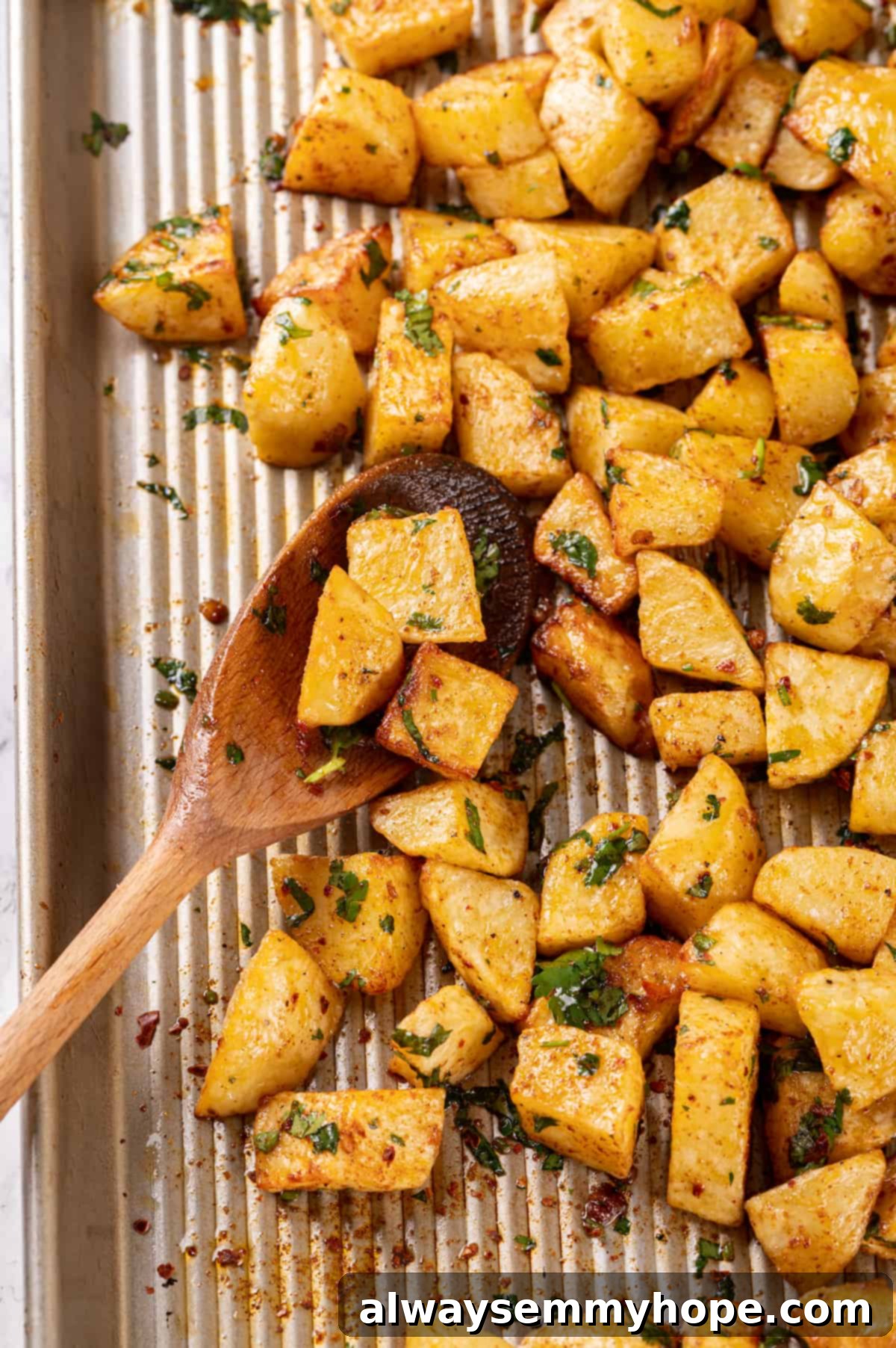 Overhead view of freshly roasted Batata Harra on a baking sheet, ready to be tossed with its spicy sauce.