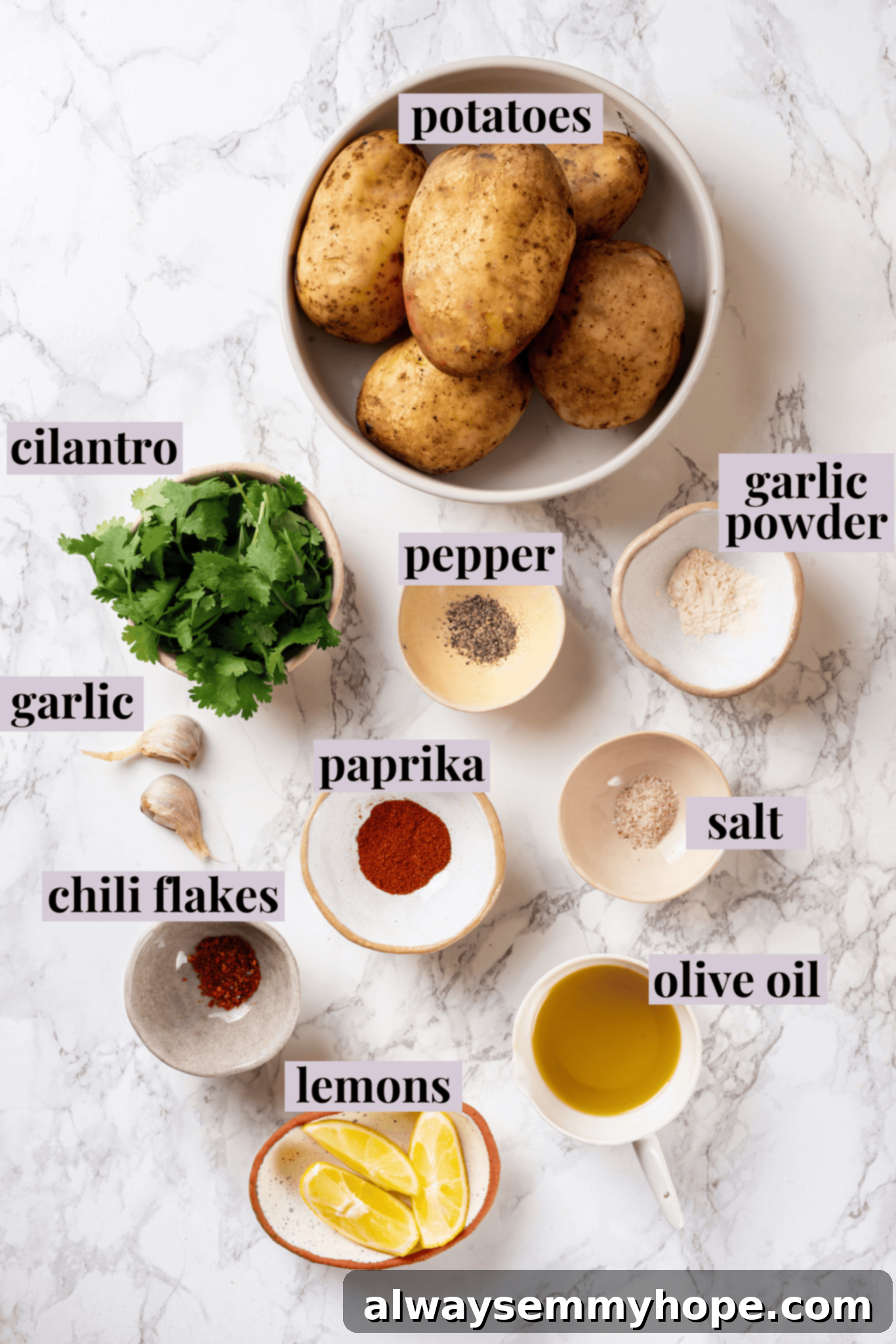 Overhead view of fresh ingredients for Batata Harra, including potatoes, fresh cilantro, garlic, lemon, olive oil, and spices on a wooden board.