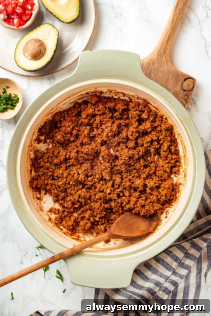 Overhead view of the finished soyrizo in a pan with a wooden spoon, showcasing its rich, crumbly texture.