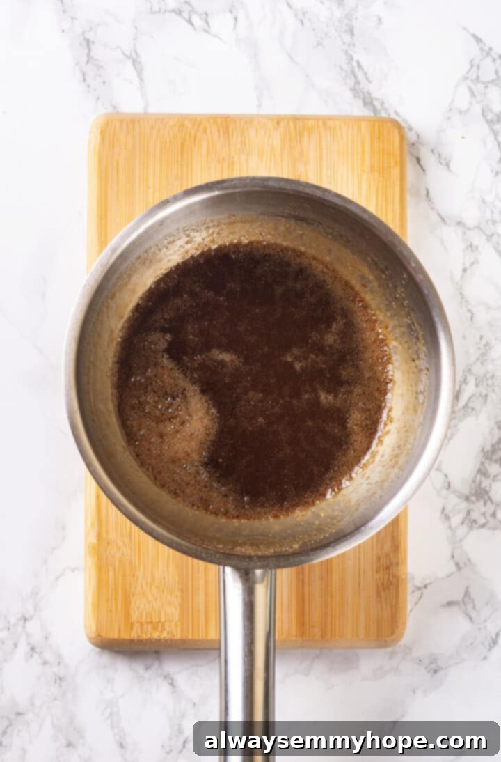 Brown Sugar Glaze in Saucepan Overhead view of the brown sugar glaze simmering in a small saucepan.