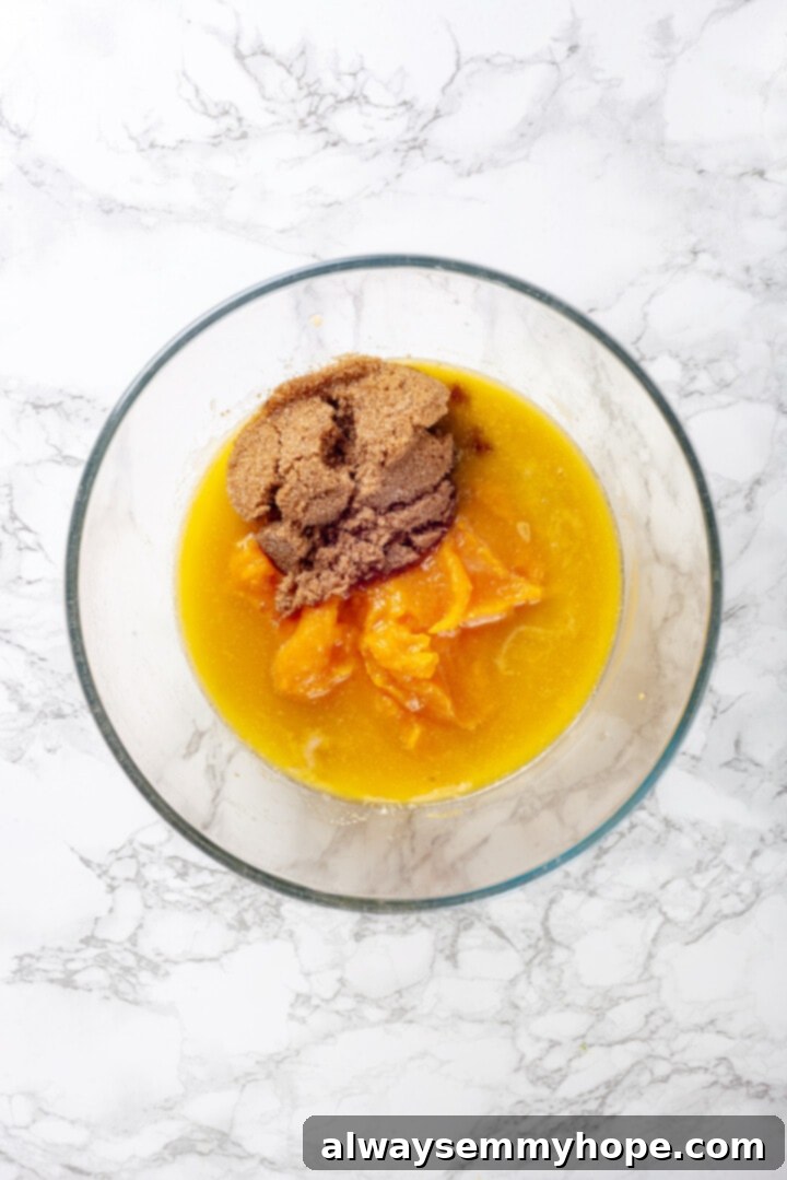 Wet Ingredients for Pumpkin Banana Muffins Overhead view of brown sugar, pumpkin puree, melted vegan butter, and mashed banana in a glass bowl before mixing.