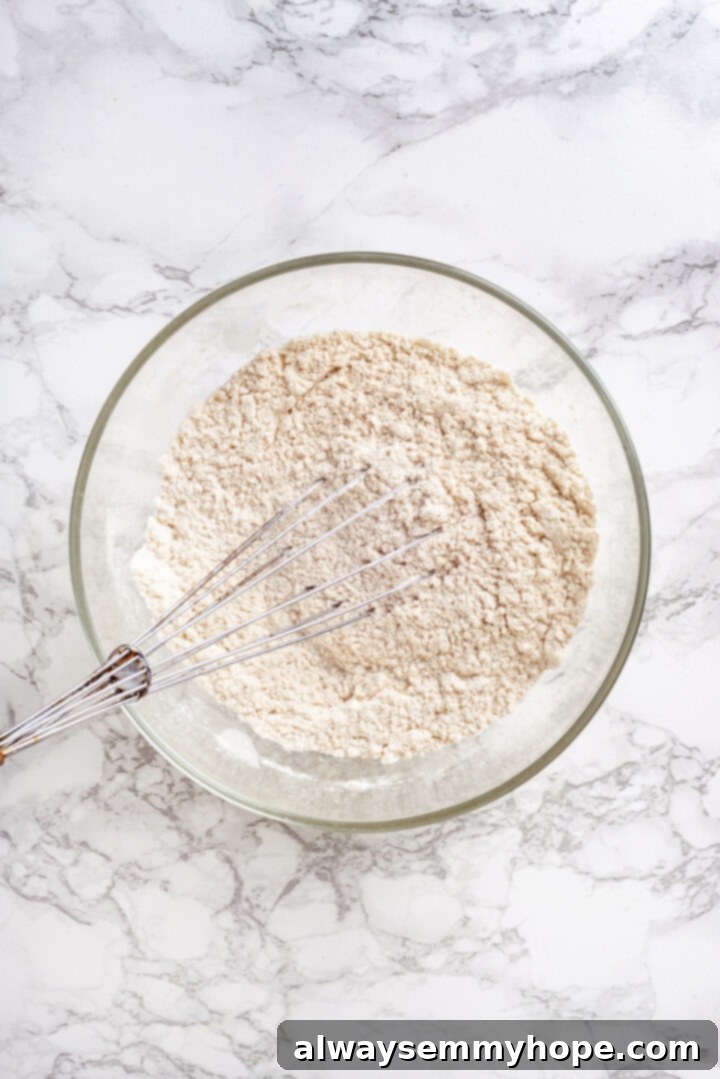 Whisking Dry Muffin Ingredients Overhead view of dry ingredients for muffins in a bowl with a whisk, ready to be combined.