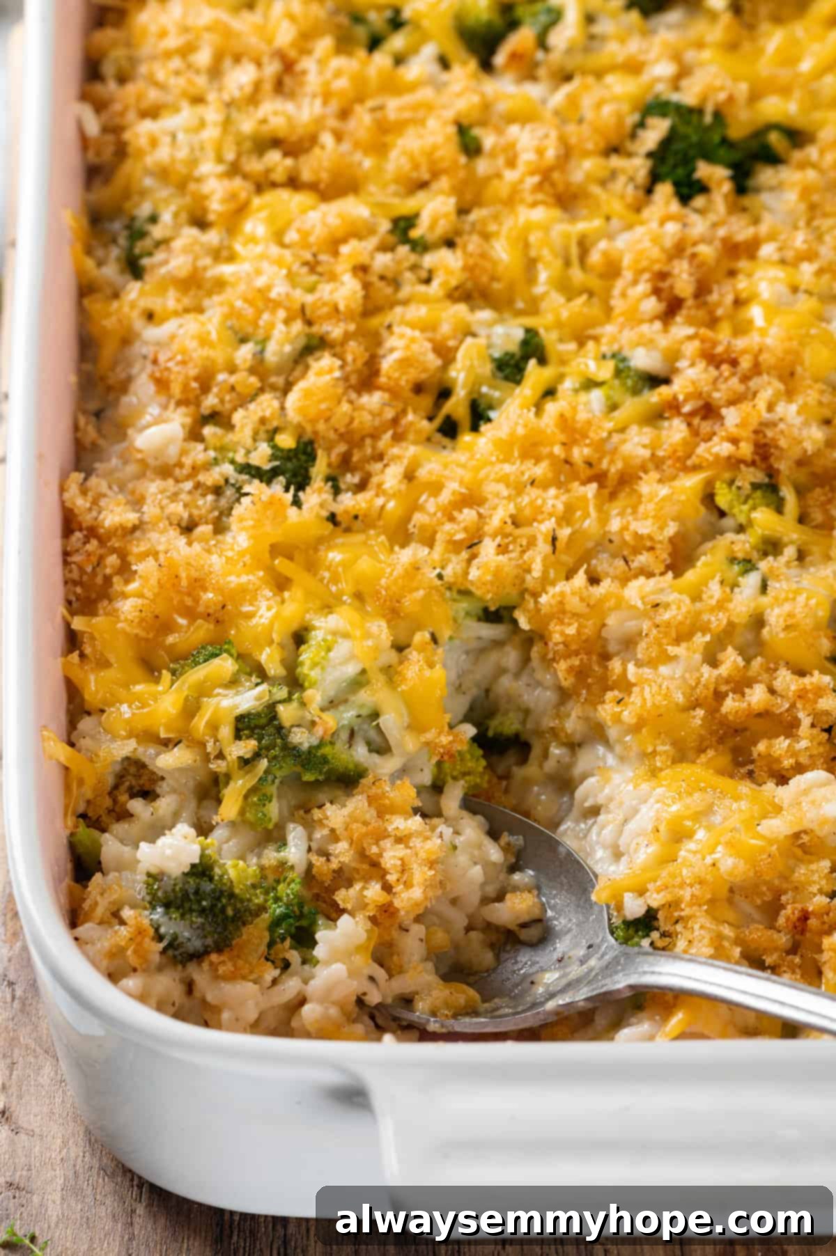 Casserole dish of broccoli cheese rice casserole with serving spoon
