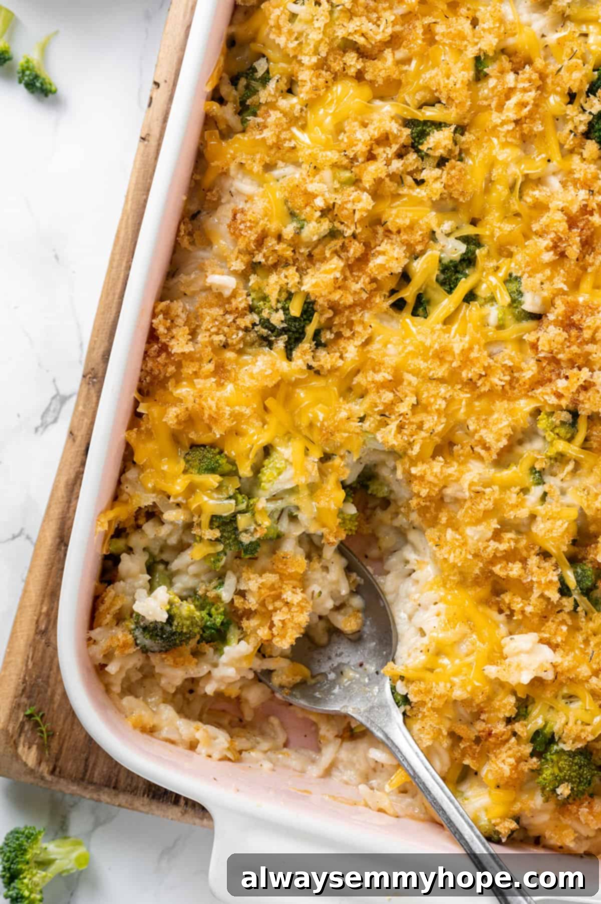 Overhead view of broccoli cheese rice casserole in casserole dish with serving spoon