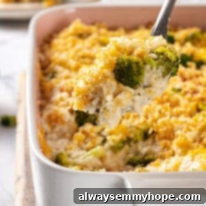 Serving spoon lifting portion of broccoli cheese rice casserole from dish