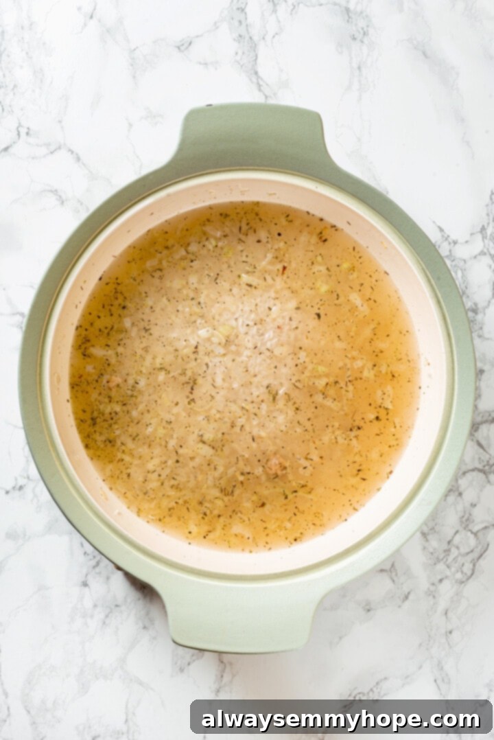 Overhead view of rice cooking in broth in pot