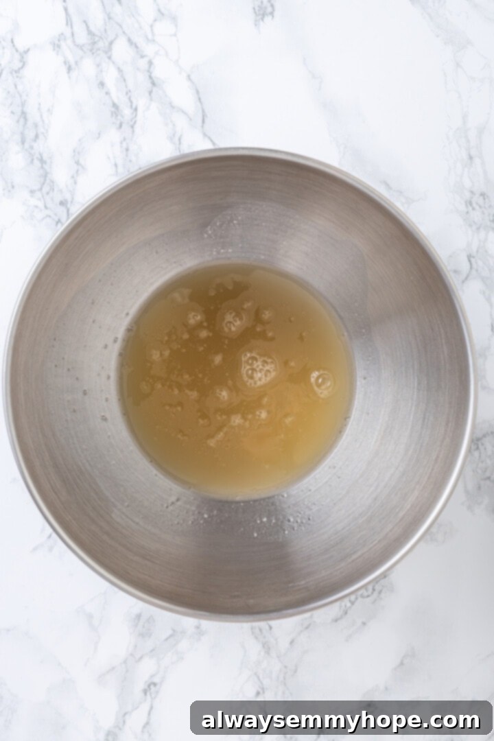 Overhead view of aquafaba in bowl with cream of tartar