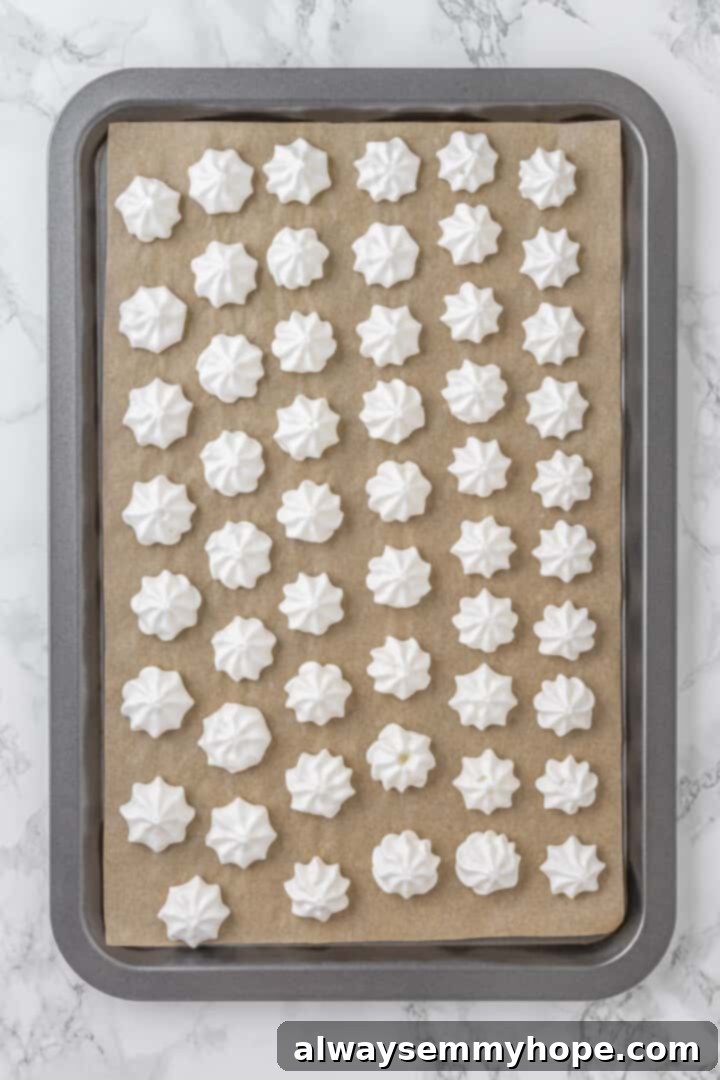 Overhead view of aquafaba meringues on parchment lined baking sheet