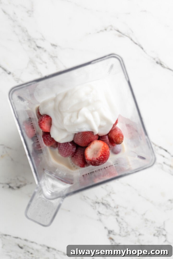Overhead view of ingredients for strawberry smoothie in blender