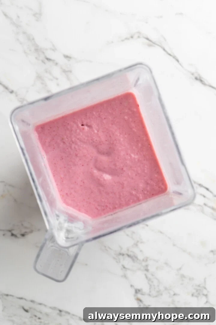 Overhead view of strawberry smoothie in blender