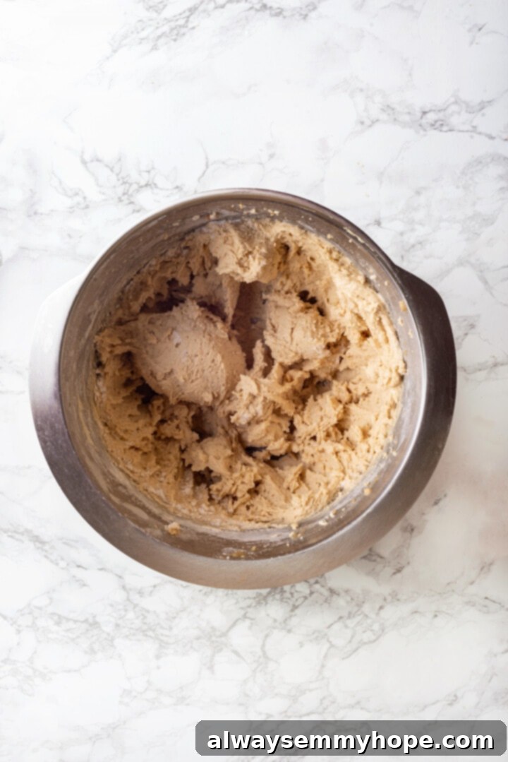 With an irresistible mix of chocolate, caramel and crispy pretzels, these kitchen sink cookies are easy to whip up and even easier to devour! Overhead view of the fully mixed cookie dough in a bowl, before the final mix-ins are added.