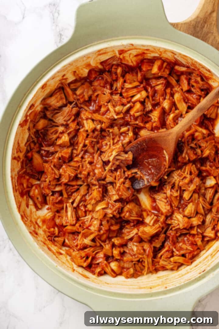 Overhead view of jackfruit taco filling in pan with wooden spoon
