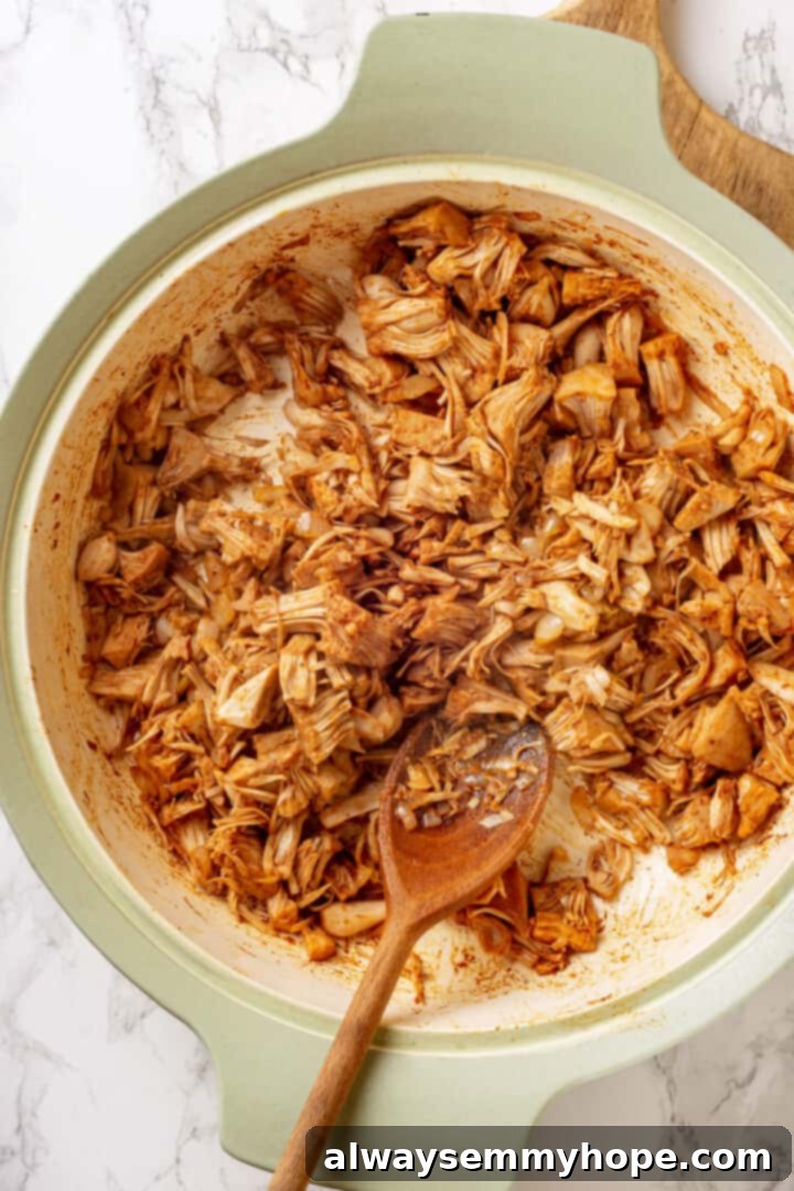 Overhead view of jackfruit in pan with wooden spoon