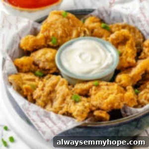 Next-Level Vegan Fried Chicken 2 Bowl of vegan fried chicken with dipping sauce in the middle and hot sauce in background