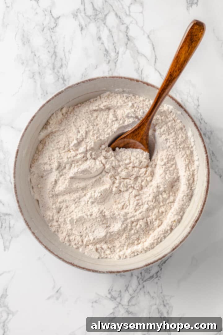 A well-mixed dredging mixture is key for crispy vegan fried chicken. Overhead view of a bowl containing the dry dredging mixture for vegan fried chicken, a blend of flour and spices.