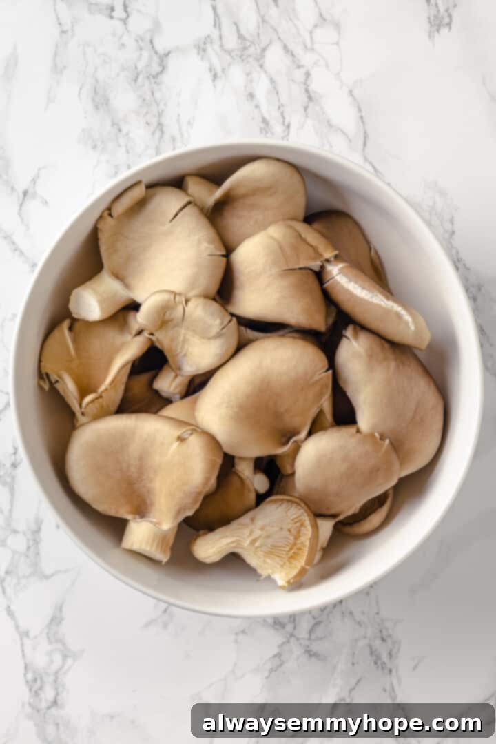 Tender oyster mushrooms, perfect for plant-based fried chicken. Overhead view of fresh oyster mushrooms in a bowl, ready for preparation.