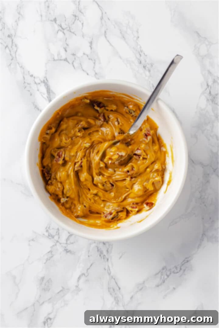 Overhead view of caramel pecan mixture in small bowl with spoon