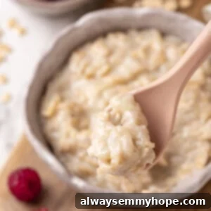 Spoonful of baby oatmeal held over bowl