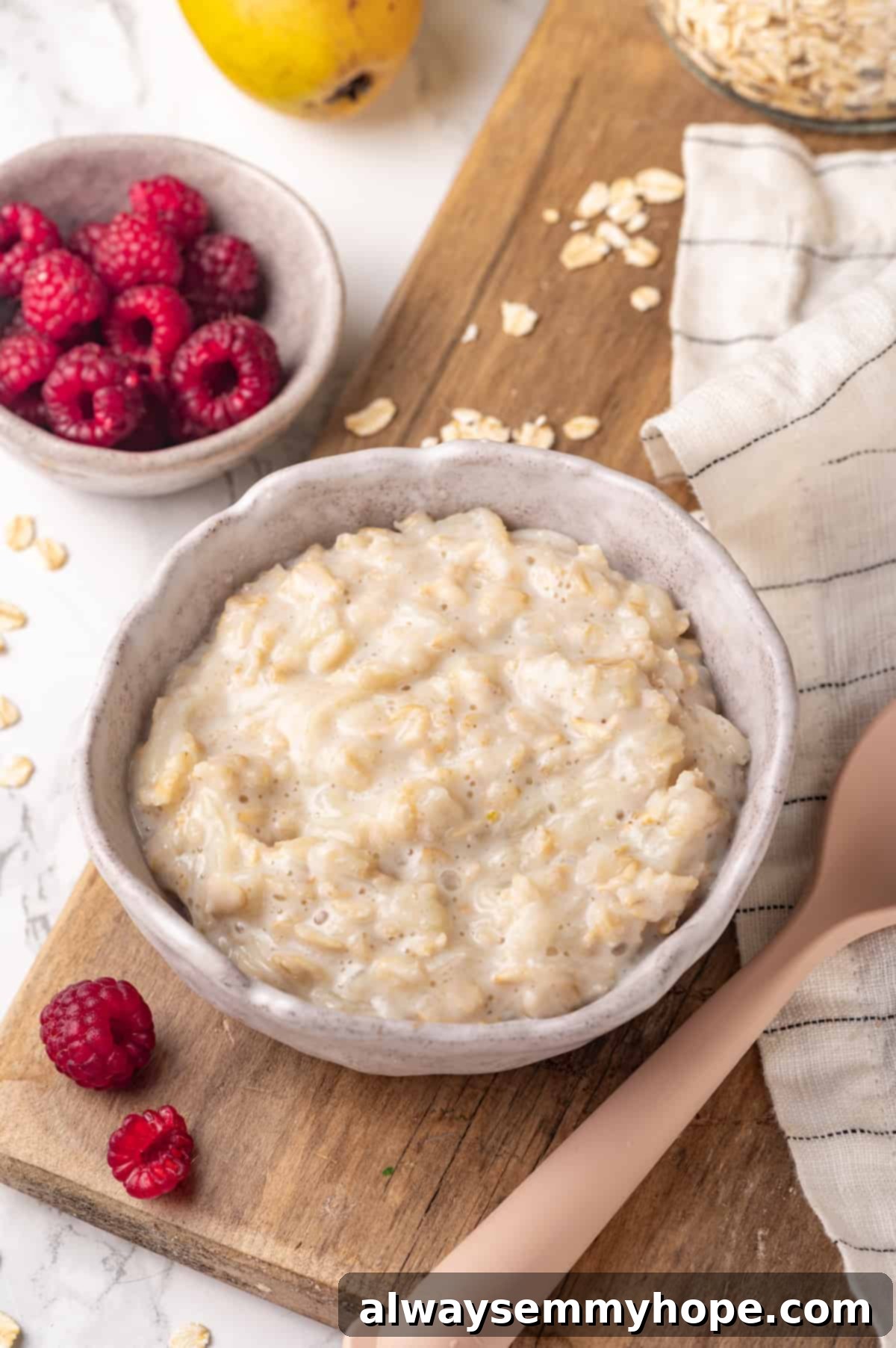Bowl of creamy baby oatmeal on a rustic wooden board, ready for feeding.