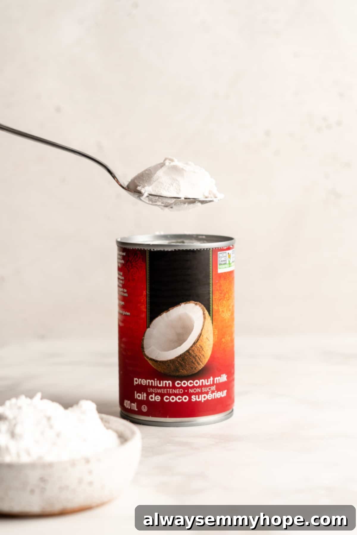 Spoonful of coconut cream being removed from coconut milk