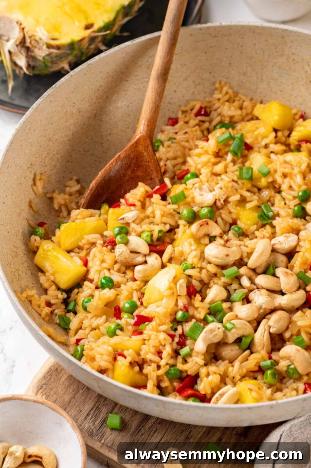 Large bowl of pineapple fried rice with wooden spoon