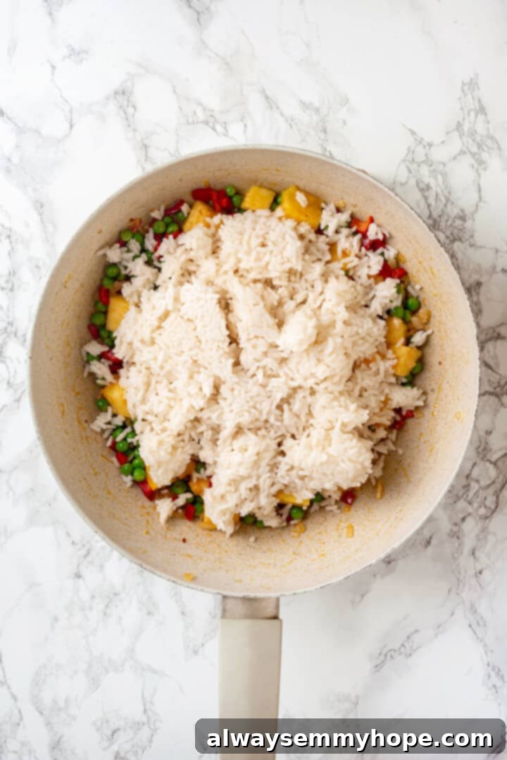 Overhead view of rice added to pan for fried rice
