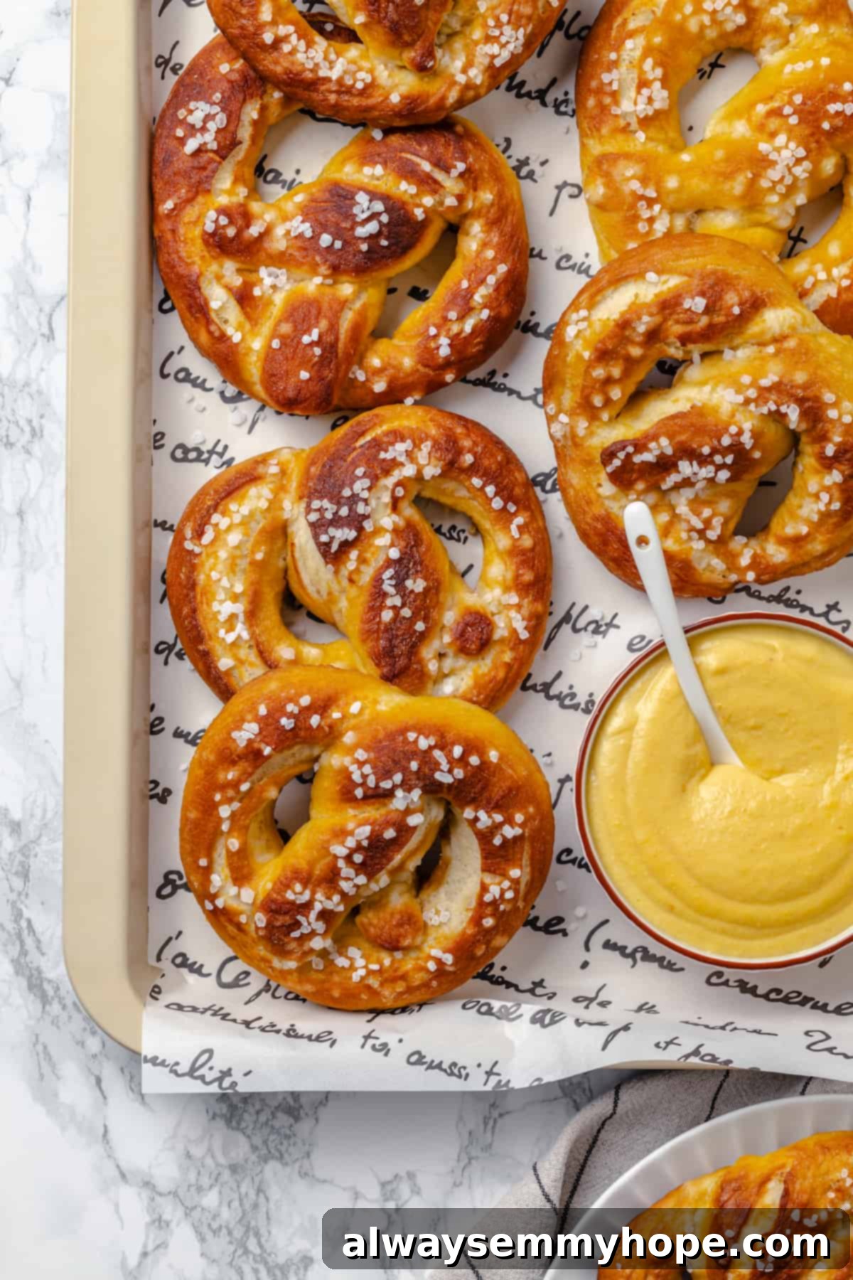 This soft pretzel recipe is fun to make and the results are outstanding—chewy, buttery, and perfect to serve with your fave dipping sauce! Overhead view of vegan soft pretzels on tray with beer cheese in bowl