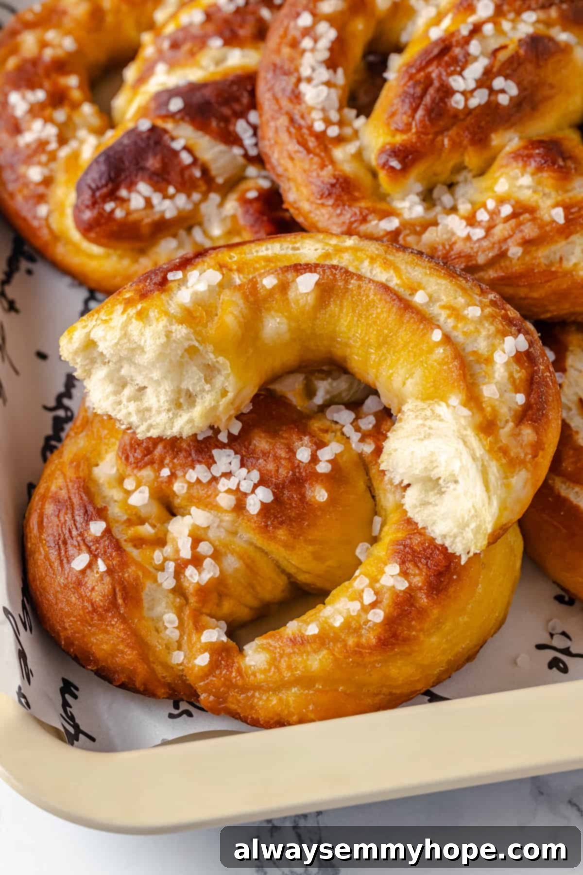 This soft pretzel recipe is fun to make and the results are outstanding—chewy, buttery, and perfect to serve with your fave dipping sauce! Closeup of soft pretzel broken in half to show interior