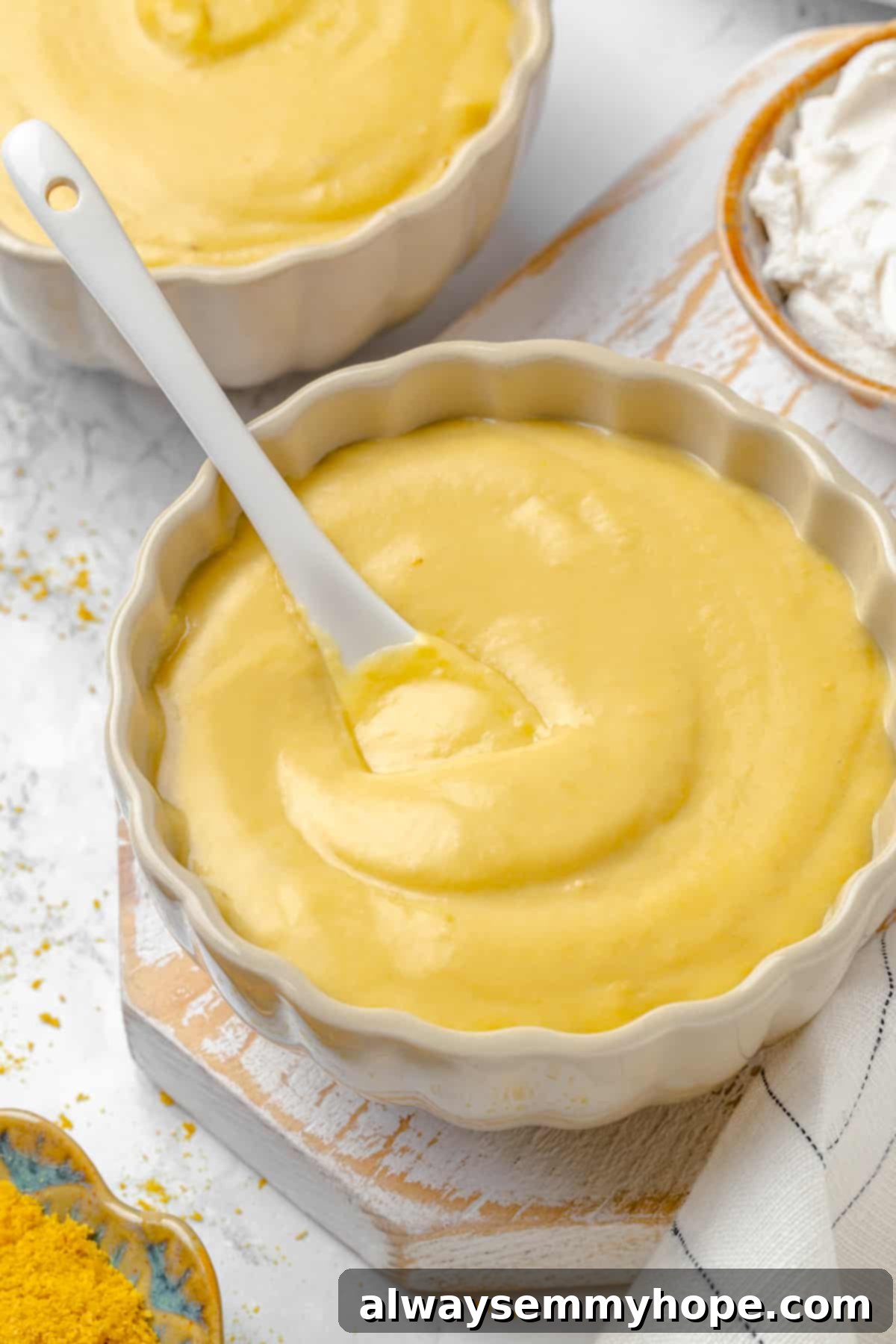 Two bowls of golden, creamy vegan pretzel dip, ready for serving