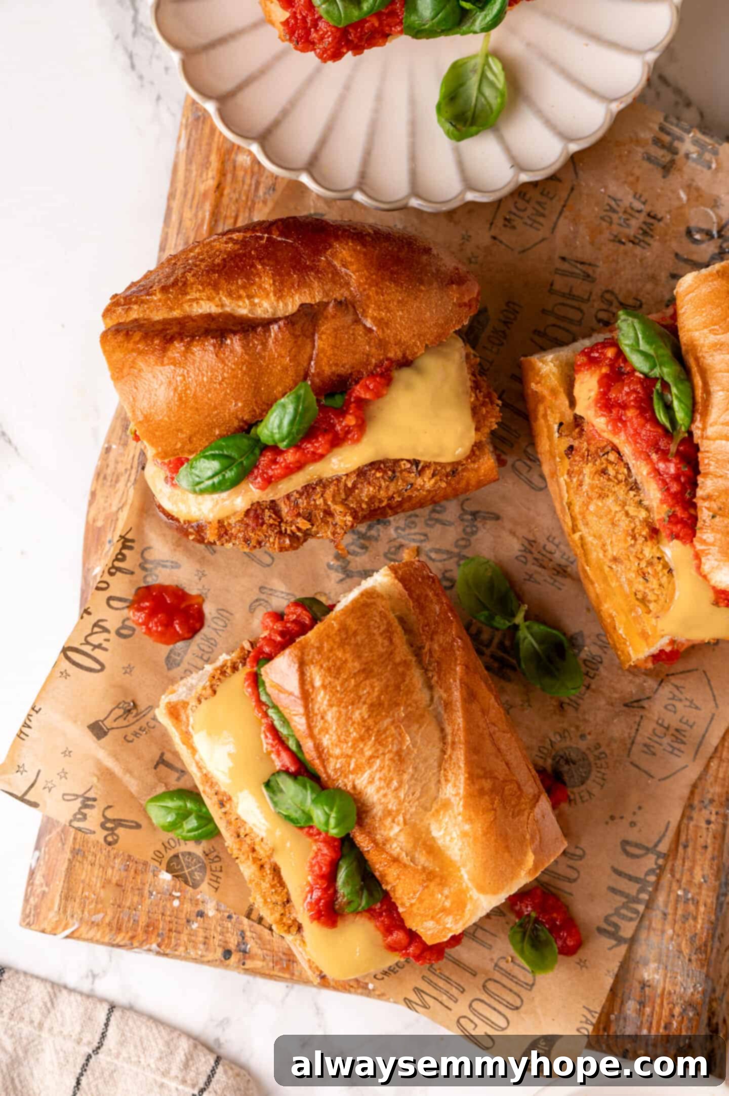 Overhead view of vegan chicken parm sandwich showcasing its crispy texture, melted cheese, and fresh basil