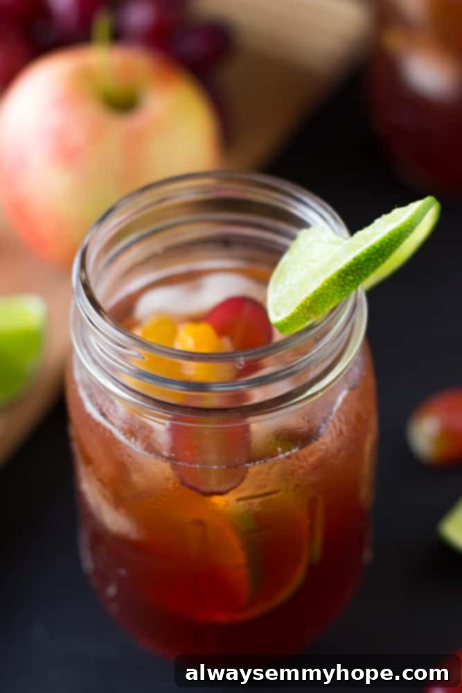 An overhead shot of a mason jar filled with Rosé Sangria, fresh fruit slices, and a vibrant lime wedge, ready to be enjoyed.
