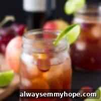 Side on shot of Rosé Sangria in a mason jar, garnished with fresh fruit and a lime wedge, ready to be served.