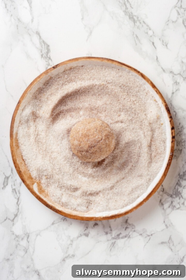 Rolling cookie dough in spiced sugar mixture, for a delicious coating
