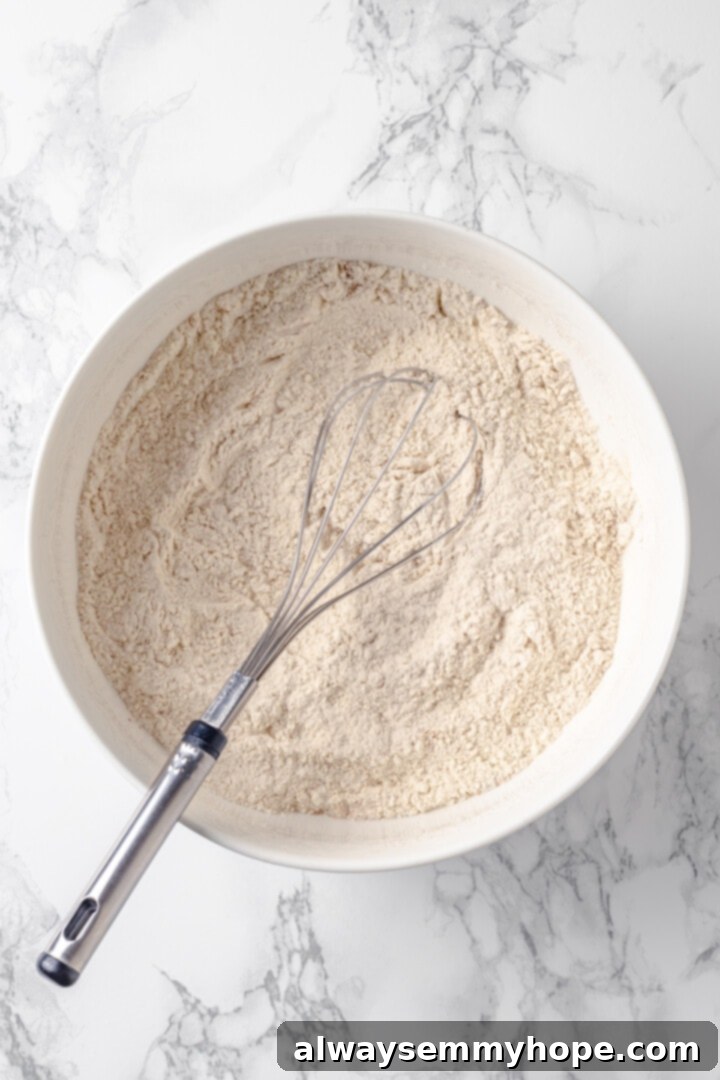 Overhead view of dry ingredients in mixing bowl with whisk