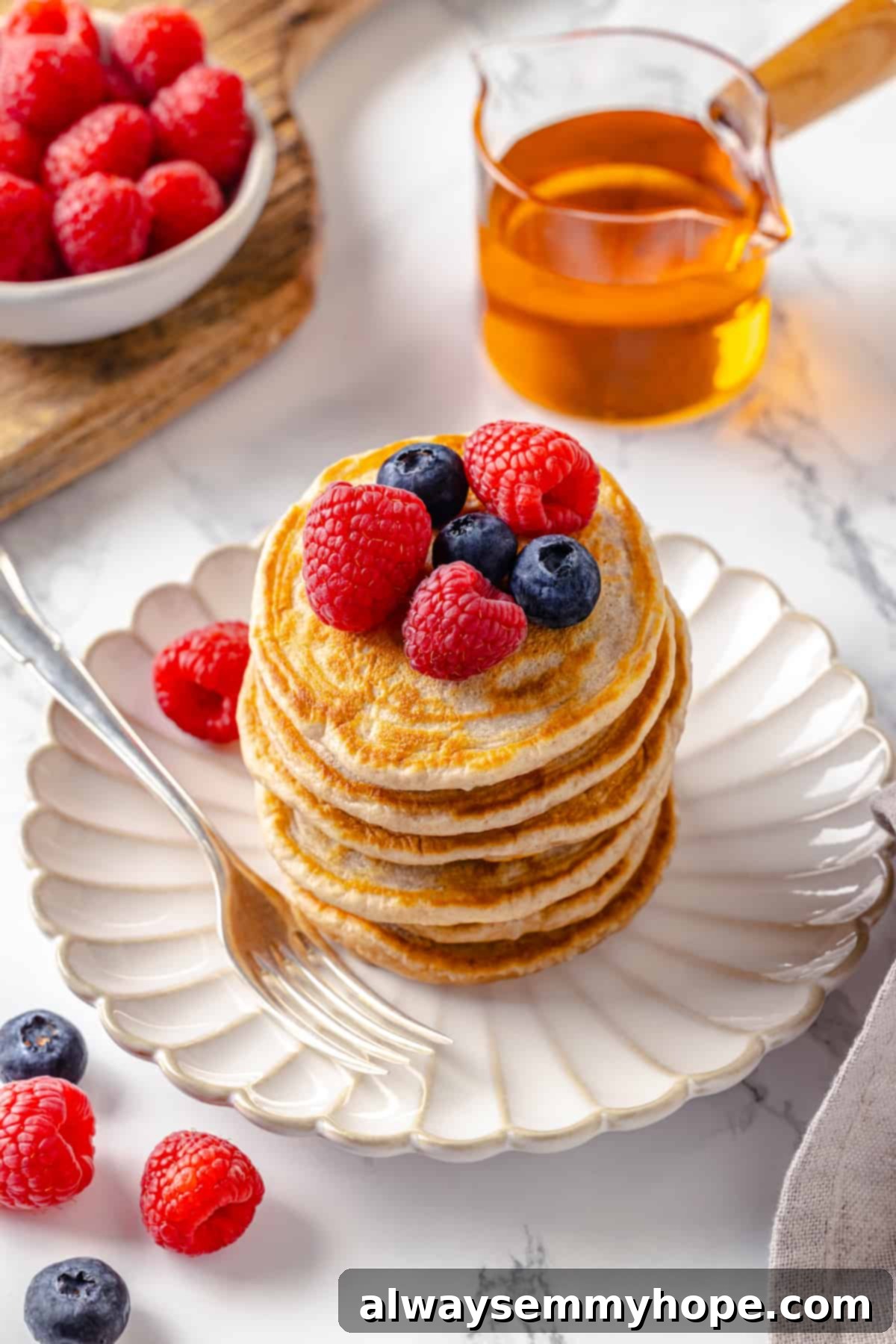 Stack of fluffy vegan silver dollar pancakes with fresh berries