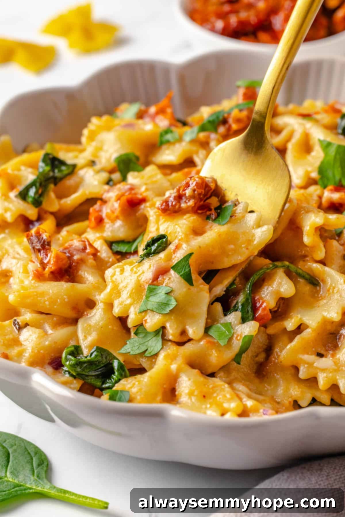 Restaurant-style creamy sun-dried tomato and spinach pasta you can easily make at home. A bowl of creamy vegan sun-dried tomato pasta with a gold fork, showcasing the rich sauce and spinach, ready to be enjoyed.