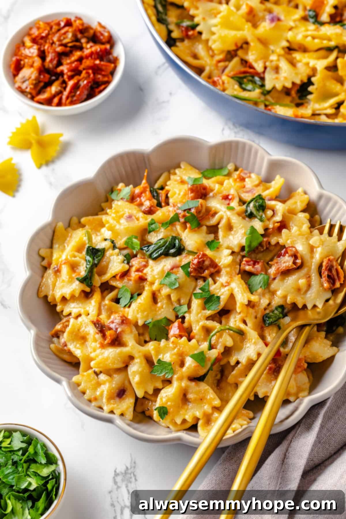 Creamy sun-dried tomato pasta with fresh spinach and parsley. A beautiful bowl of creamy vegan sun-dried tomato pasta with wilted spinach, garnished with fresh parsley.
