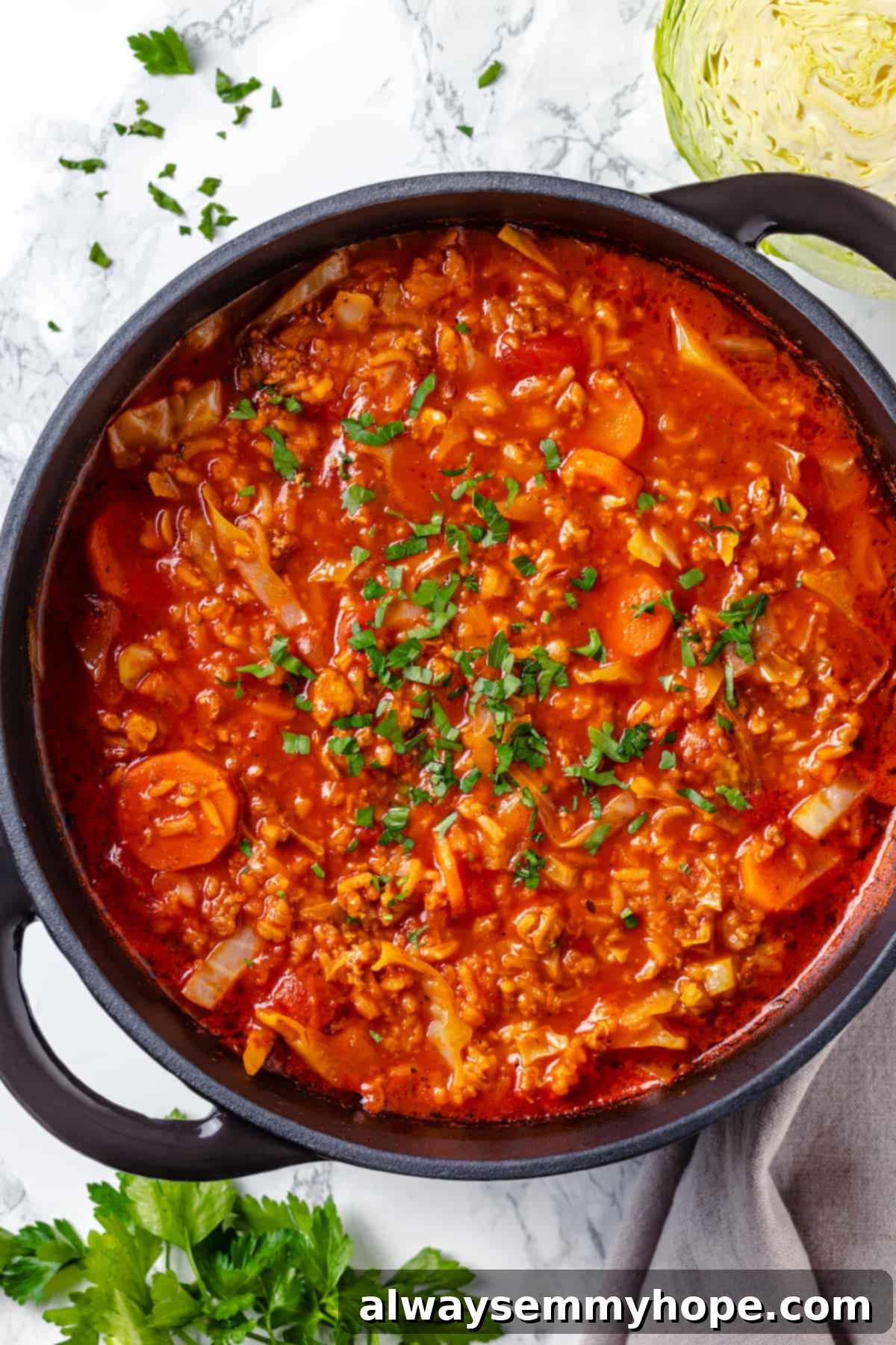 Satisfying cabbage roll soup is a filling meal in a bowl! Skip all the work and enjoy your cabbage rolls in the form of a hearty soup recipe. Overhead view of a steaming pot of hearty vegan cabbage roll soup, showcasing its rich texture and vibrant ingredients.