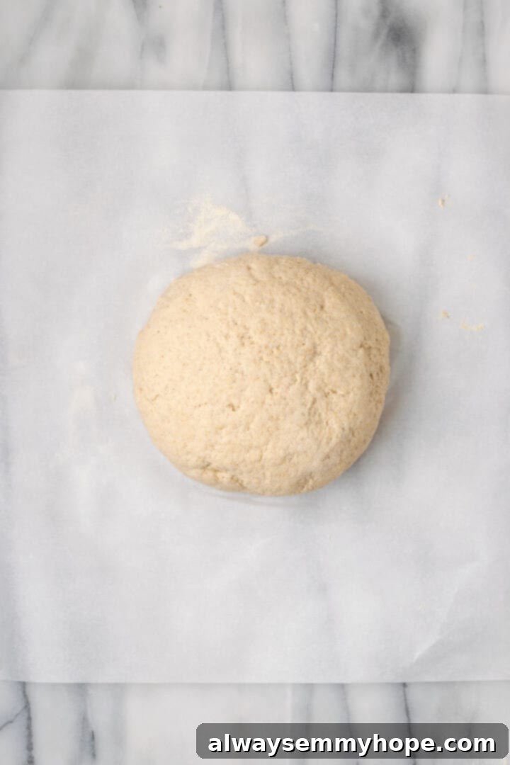 Overhead view of ball of dough on parchment paper