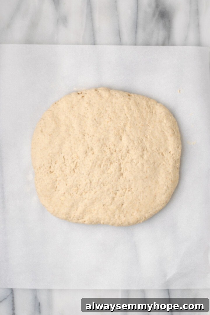 Overhead view of gluten-free sandwich bread dough flattened onto parchment paper