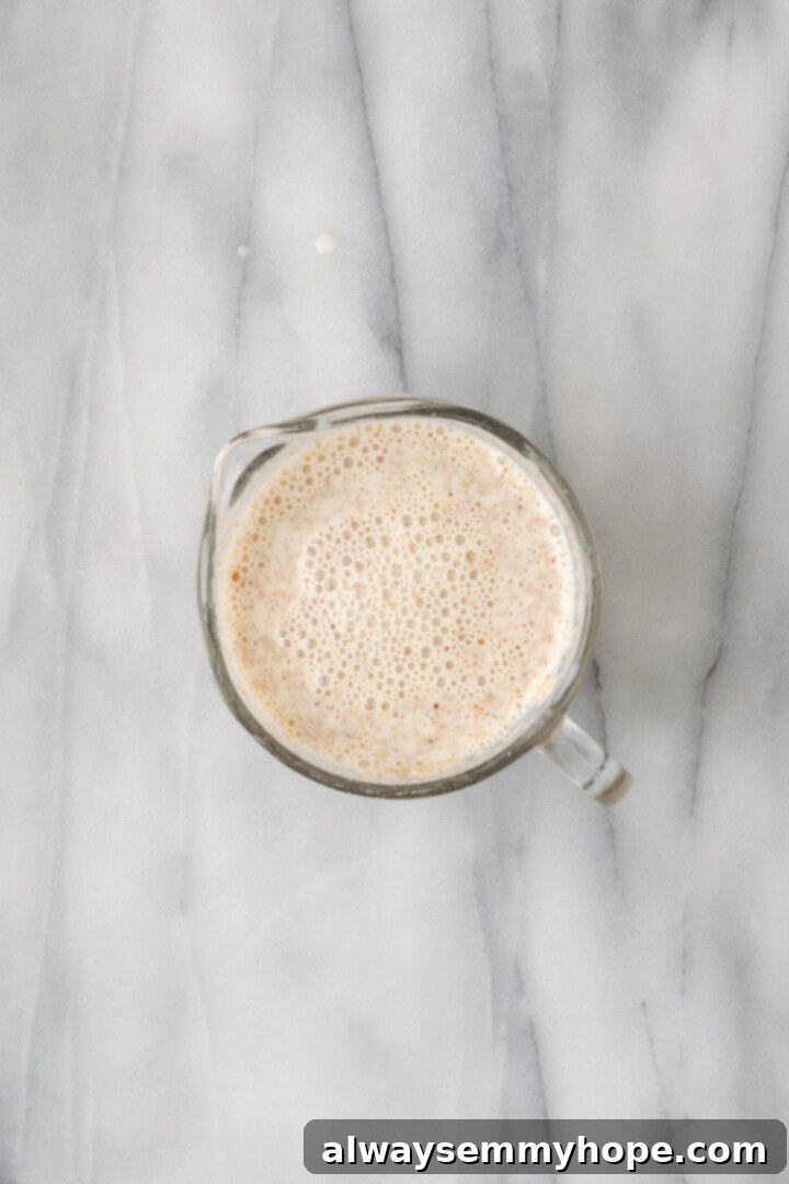 Overhead view of psyllium and soy milk in liquid measuring cup after whisking