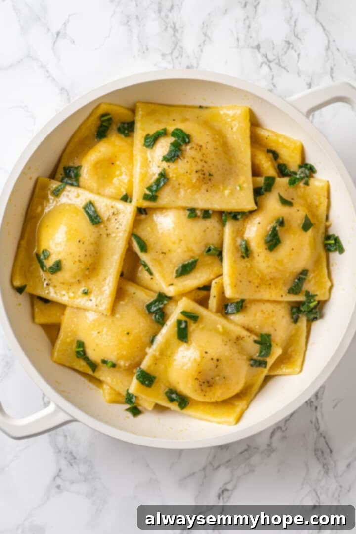 Butternut squash ravioli is fun to make at home and the results are delicious. Tender pasta pockets filled with creamy, caramelized squash! Butternut squash ravioli in pan with fresh sage