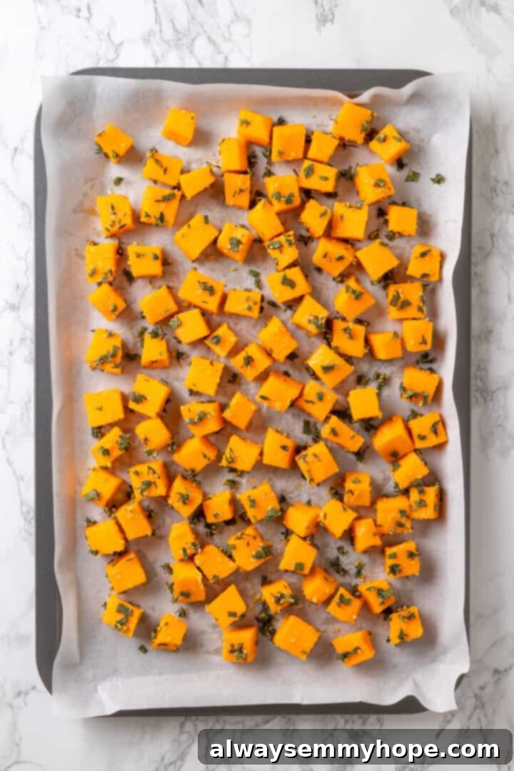 Butternut squash ravioli is fun to make at home and the results are delicious. Tender pasta pockets filled with creamy, caramelized squash! Overhead view of butternut squash cubes on sheet pan