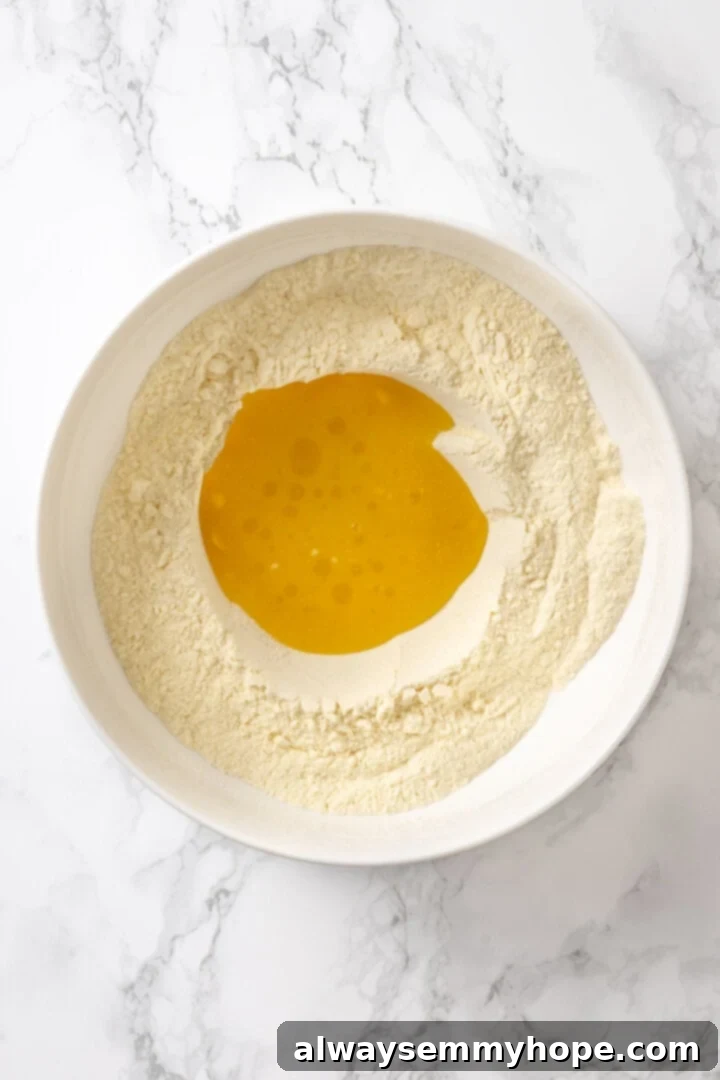 Butternut squash ravioli is fun to make at home and the results are delicious. Tender pasta pockets filled with creamy, caramelized squash! Liquid ingredients added to bowl of dry ingredients for pasta