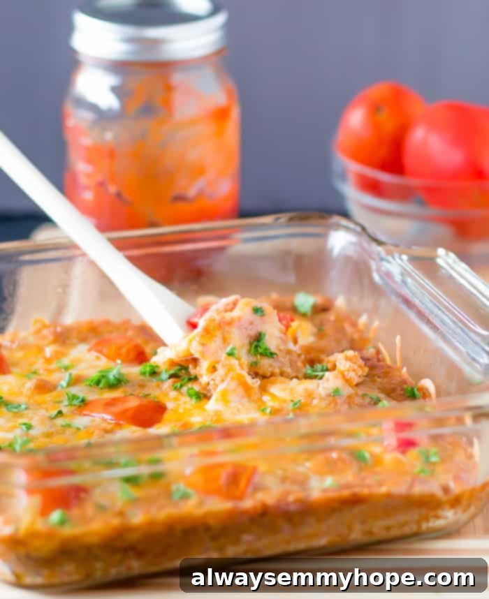 A wooden spoon scooping out a generous portion of warm cheesy quinoa casserole from a baking dish, revealing its creamy texture and rich ingredients.