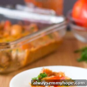 A perfectly baked portion of Cheesy Quinoa Casserole on a white plate, garnished with fresh herbs, showcasing its delicious texture and inviting warmth.