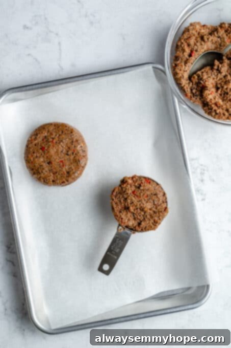 Black bean burgers are made with cooked quinoa, sautéed onions, and smoky strawberry BBQ sauce! Veggie burgers have never tasted this good! Quinoa and black bean burger mixture in a measuring cup.